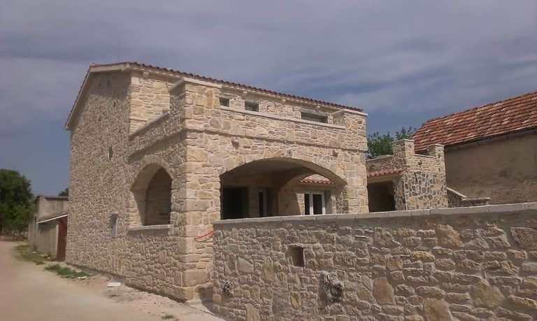 Kuća s kamenim pročeljem i dvorišnom ogradom