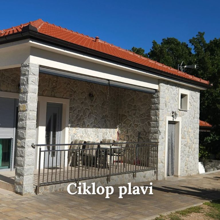 Pogled na pročelje i terasu kuće obložene kamenom ciklop plavi