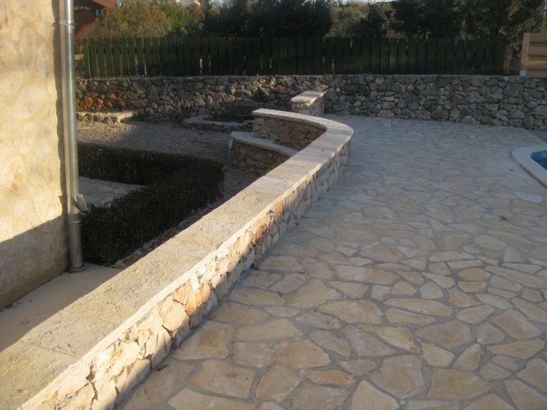 Popločano dvorište s kamenim zidom